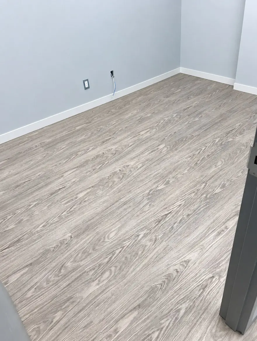 Office room with new grey wood-look vinyl plank flooring and freshly painted walls